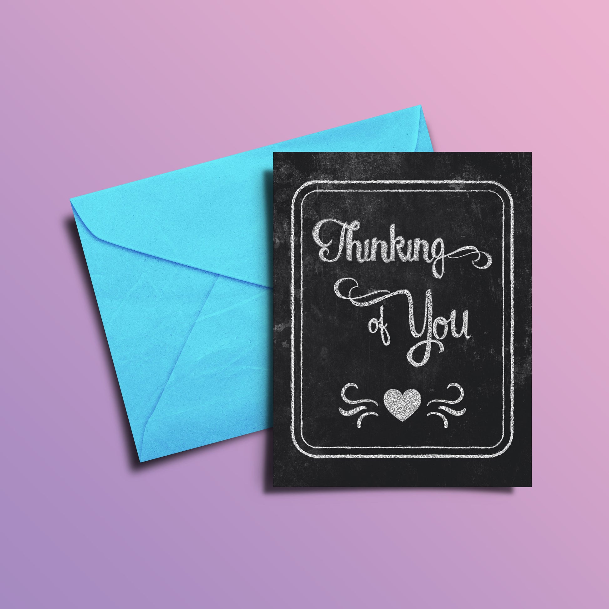 Chalk-board style card, "Thinking of you" in chalk on black, over blue envelope with purple background.